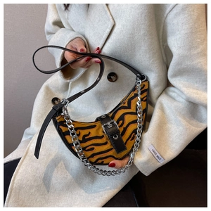 Detail of tiger print hobo bag with silver chain and leather strap on wool coat