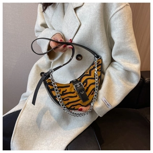 Détail du sac bandoulière croissant avec rayures de tigre et chaîne argentée