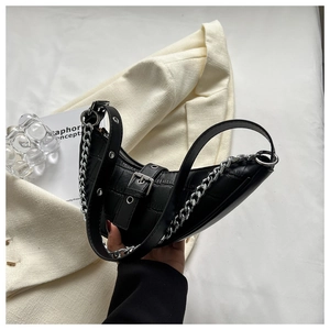 Détail du sac lune noir en cuir crocodile avec chaîne argentée et bandoulière à œillets
