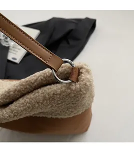 Detail of beige faux shearling and brown leather handbag with silver metal ring connector