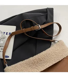 Detail of adjustable brown leather strap and soft fleece trim on the bucket bag