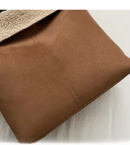 Detail of brown suede bucket bag with beige fleece lining and durable double stitching