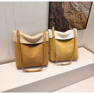 Dettaglio di borse a secchiello in camoscio marrone e giallo con bordo in shearling bianco