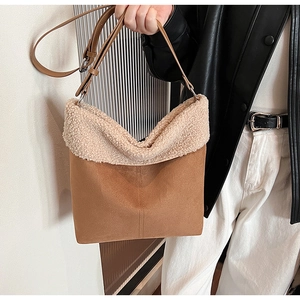Detail of brown suede shoulder bag with cream faux fur trim and adjustable strap