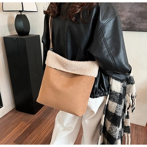 Detail of camel suede and off-white faux shearling trim on this tote shoulder bag