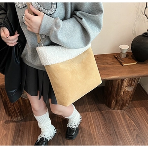 Detail of yellow suede shoulder bag with white faux shearling trim and slim leather strap