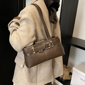 Retro dark brown leather underarm bag with silver buckles shown on a model's shoulder