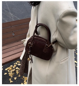 Fashionable dark brown suede crossbody bag styled in a scenic autumn outdoor setting