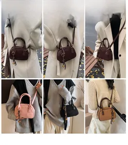 Mini suede crossbody bag detail showing various colors with metal ring and bell charm