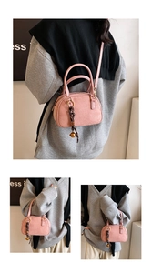 Detail of dusty rose matte crossbody bag with woven pendant and golden hardware accents