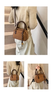 Detail of retro brown suede bowling bag with floral scarf and metallic ball charm