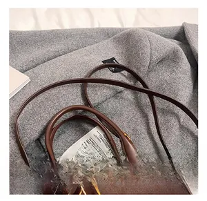Macro detail of dark brown matte leather handbag with metallic ring and decorative card