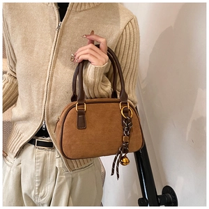 Detailed macro view of brown frosted leather handbag texture with gold hardware accents