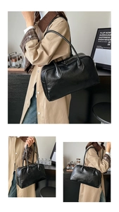 Close-up of the vintage pleated leather texture and shoulder strap on a black tote bag