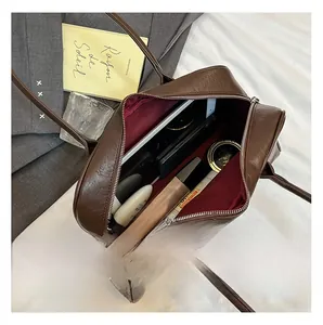 Interior view showing the large capacity and dark red lining of the brown leather handbag