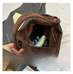 Detailed view of spacious interior of brown suede tote bag with striped lining and zipper