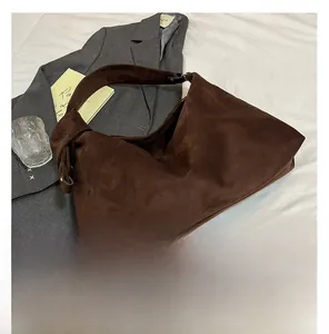 Deep brown suede large tote bag styled with a minimalist hobo design on a white fabric surface