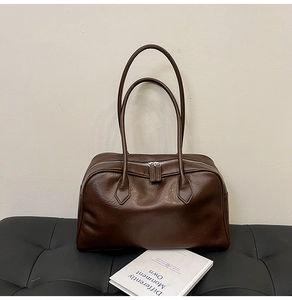 Macro detail of the chocolate brown tote bag showing matte texture and silver zipper