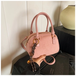 Detail of pink Boston bag showing mixed leather textures and woven tassel with gold bell