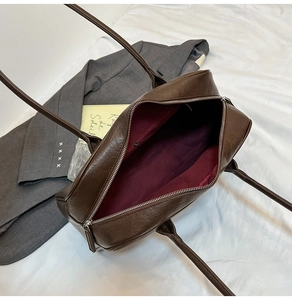 Interior view of brown tote bag showing burgundy lining and inner zipper pocket detail