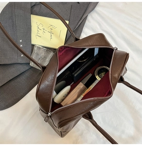Detail view of large dark brown tote bag showing spacious interior and daily essentials