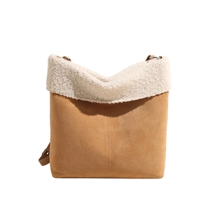 Chic brown suede bucket bag with white faux shearling trim and adjustable shoulder strap