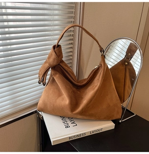 Detailed texture of brown matte suede shoulder bag with unique side knot decoration