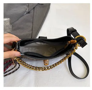 Detail view of the black leather saddle bag interior with dual compartments and gold chain