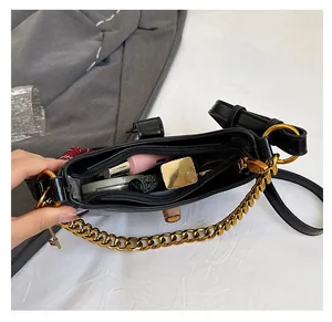 Interior view of black crescent shoulder bag showing spacious storage with gold chain detail