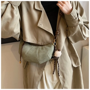 Detail of grey-green matte dumpling bag with knotted strap and ice cream pendant accessory