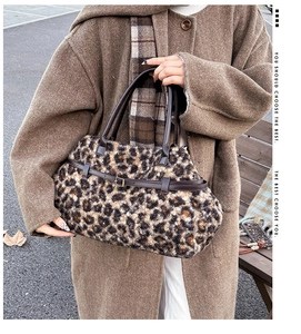 Detailed view of plush leopard print fabric and brown leather handle on a winter tote bag