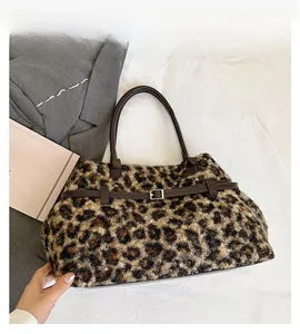 Detail of leopard print faux fur tote with leather straps and metal buckle accent
