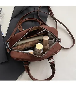Internal view of dark brown suede handbag showing large capacity for essentials