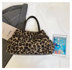Size comparison of a plush leopard print tote bag next to a tablet and blazer