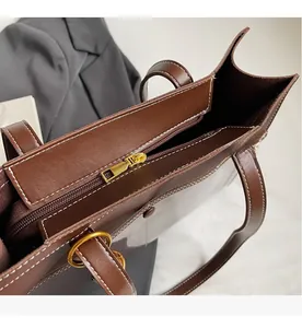 Detail of vintage brown tote bag with white contrast stitching and smooth gold zipper