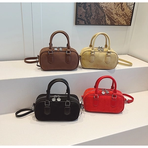 Row of small suede Boston bags in brown, yellow, black and red on a white stand