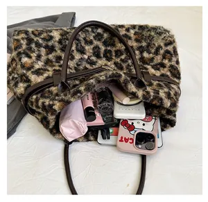 Detail showing the large capacity of a leopard print tote bag with various daily items