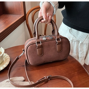 Détail du sac à main vintage marron en daim et cuir sur un bureau en bois