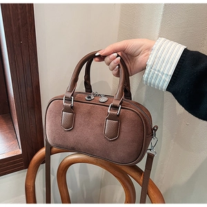 Détail du sac bowling en daim marron et cuir grainé avec double fermeture à glissière