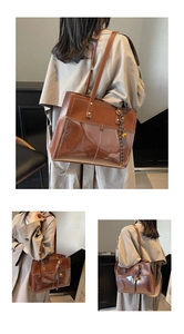 Detail view of deep brown tote bag featuring high-gloss texture and contrast stitching detail