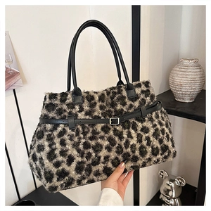 Detail of plush leopard print tote bag featuring black leather straps and silver buckle