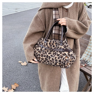 Detail of plush leopard print tote bag with soft faux fur texture and brown leather handles