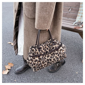 Detail of winter leopard print faux fur tote bag with brown leather handles and buckle