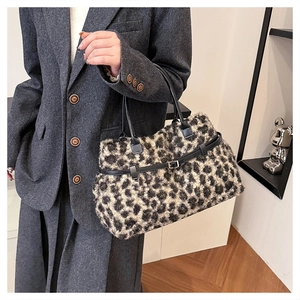 Detail of plush leopard print tote bag styled with a gray wool suit in a modern room