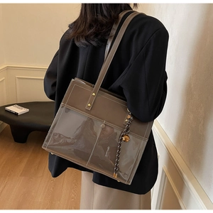 Detailed back view showing the large brown leather tote bag with transparent PVC pocket