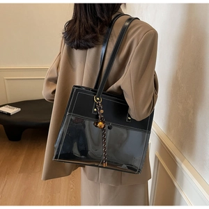 Detail of black tote bag with transparent PVC paneling and white contrast stitching detail
