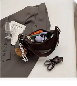 Internal view of dark brown crescent bag showing storage capacity with everyday essentials