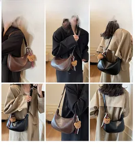 Detailed look at the half-moon hobo bag styled with a plush bear charm and ribbon
