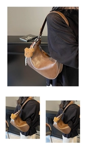 Detailed close-up of a brown leather hobo bag with a plush bear charm and metal hardware