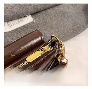 Macro shot of dark brown leather bag showing gold zipper detail and fine texture